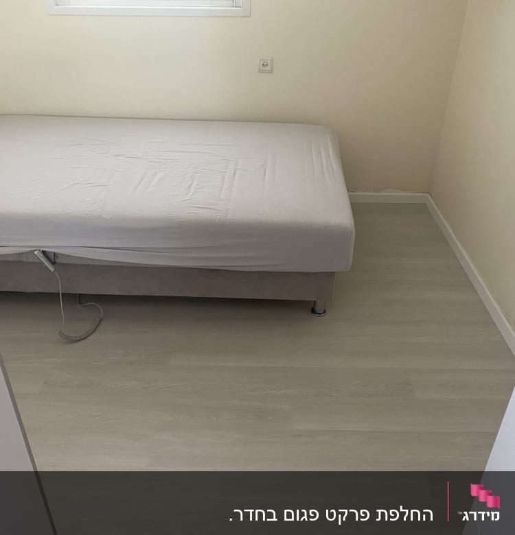 רצפת פרקט בהירה בחדר שינה עם מיטה